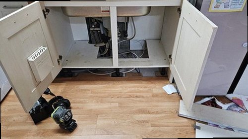 서대문구 누수탐지 싱크대 하부 배관과 벽면 누수 흔적을 점검하는 모습